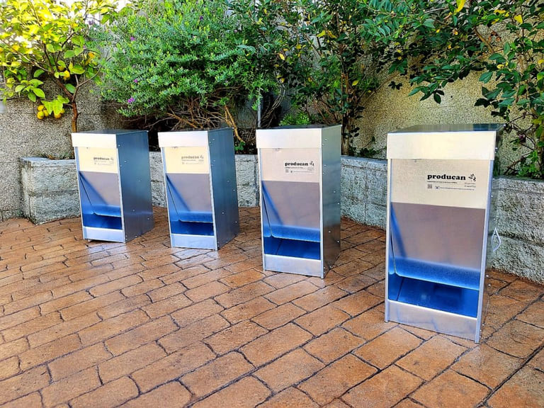 Cuatro comederos automáticos Producan alineados en un jardín