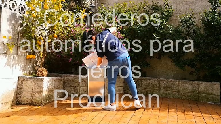 Llenando de pienso un comedero Producan en el jardín